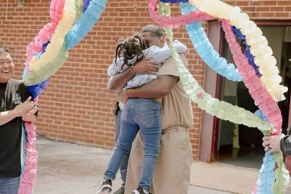 A man embracing a family member on release day